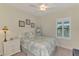 Bedroom with a light blue comforter, white nightstand, and plantation shutters at 26906 Weiskopf Dr, Englewood, FL 34223