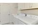 Laundry room with washer, dryer, and overhead shelving at 26906 Weiskopf Dr, Englewood, FL 34223