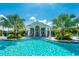 Resort-style pool with a clubhouse and palm trees in a community at 26906 Weiskopf Dr, Englewood, FL 34223
