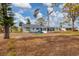 View of the home from the backyard, showing unkempt grass at 321 S Mango St, Englewood, FL 34223