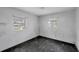 Small bedroom with two windows and dark flooring at 321 S Mango St, Englewood, FL 34223