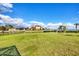 A large grassy backyard is surrounded by a black metal fence and waterfront properties at 3522 Fox Ter, Port Charlotte, FL 33981