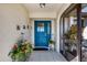 Inviting entryway showcasing a bright blue front door, potted flowers, and a charming outdoor seating area at 3522 Fox Ter, Port Charlotte, FL 33981