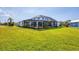 Expansive screened patio with black framing offers views of the manicured lawn at 3522 Fox Ter, Port Charlotte, FL 33981