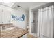 Bathroom with granite countertop, walk-in shower, and beach mural at 4204 Cockrell St, Port Charlotte, FL 33948