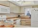 Kitchen features white appliances, wood cabinets, and a window at 4260 Placida Rd # 18C, Englewood, FL 34224
