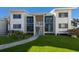 Modern condo building with white exterior, green lawn, and walkway at 5000 Gasparilla Rd # 26A, Boca Grande, FL 33921