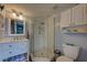 Bathroom with corner shower, white vanity, and white cabinets at 5031 N Beach Rd # 112, Englewood, FL 34223