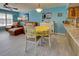 Bright dining area with white table and chairs, yellow tablecloth, and leather couch at 5031 N Beach Rd # 112, Englewood, FL 34223