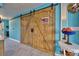 Entryway with rustic barn doors and light gray flooring at 5031 N Beach Rd # 112, Englewood, FL 34223
