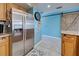 Stainless steel refrigerator in a kitchen with light wood cabinets and blue walls at 5031 N Beach Rd # 112, Englewood, FL 34223