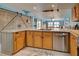 Modern kitchen with island, stainless steel appliances, and light wood cabinets at 5031 N Beach Rd # 112, Englewood, FL 34223