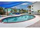 Refreshing kidney-shaped pool with blue lounge chairs and shade at 5031 N Beach Rd # 112, Englewood, FL 34223