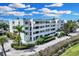 Three-story building with white exterior, balconies, and lush landscaping at 5700 Gulf Shores Dr # B234, Boca Grande, FL 33921
