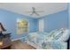 Light blue bedroom with a queen bed, ceiling fan, and window at 60 White Marsh Ln, Rotonda West, FL 33947