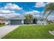 Single-story home with gray exterior, landscaping and two-car garage at 60 White Marsh Ln, Rotonda West, FL 33947