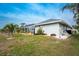 Exterior view of single story house with landscaped yard at 60 White Marsh Ln, Rotonda West, FL 33947