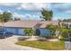 Cute light blue house with a two-car garage and lush landscaping at 610 Apple Ln, Englewood, FL 34223