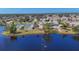 Aerial view of community with pool, tennis courts, and lake at 610 Apple Ln, Englewood, FL 34223