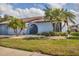 Two-story light blue house with palm trees and a well-maintained lawn at 610 Apple Ln, Englewood, FL 34223