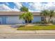 Light blue house with attached garage and palm trees at 610 Apple Ln, Englewood, FL 34223