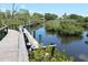 Serene waterfront view with wooden walkway at 6699 San Casa Dr # S1, Englewood, FL 34224