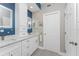 Double vanity bathroom with white cabinets and a blue accent wall at 8226 Harborside Cir, Englewood, FL 34224