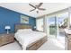 Bright bedroom with king-size bed and sliding glass doors leading to a balcony at 8226 Harborside Cir, Englewood, FL 34224
