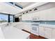 Modern kitchen featuring white cabinets, updated appliances, and tile floors at 8226 Harborside Cir, Englewood, FL 34224