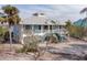 Two-story waterfront home with metal roof and teal accents at 8245 Manasota Key Rd, Englewood, FL 34223