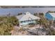 Two-story waterfront home with metal roof and teal accents at 8245 Manasota Key Rd, Englewood, FL 34223
