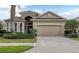 Tan one-story house with a two-car garage and lush landscaping at 9507 Carnaby Dr, Venice, FL 34293