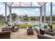 Relaxing screened patio overlooking a pond with wicker furniture at 9507 Carnaby Dr, Venice, FL 34293