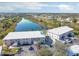 An aerial view showing well-maintained apartment buildings with a serene lake and lush landscaping at 9700 Fiddlers Green Cir # 117, Rotonda West, FL 33947