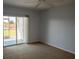 Cozy bedroom with neutral carpet and sliding glass doors to a private lanai at 9700 Fiddlers Green Cir # 117, Rotonda West, FL 33947