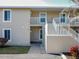 The exterior shows a well maintained two story condo with stairway access to units, and manicured landscaping at 9700 Fiddlers Green Cir # 117, Rotonda West, FL 33947