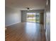 Bright living room featuring wood floors and sliding glass doors overlooking a tranquil lake at 9700 Fiddlers Green Cir # 117, Rotonda West, FL 33947