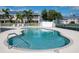 Community pool featuring clear blue water and a metal handrail for easy access to enjoy the water at 9700 Fiddlers Green Cir # 117, Rotonda West, FL 33947