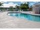 A beautiful pool on a sunny day with palm trees and lush greenery in the background at 9700 Fiddlers Green Cir # 117, Rotonda West, FL 33947