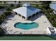 Aerial shot of a kidney-shaped community pool, with a recreation center and tennis courts at 9700 Fiddlers Green Cir # 117, Rotonda West, FL 33947