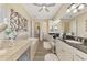 This primary bathroom showcases a soaking tub, dual sinks with granite counters, and decorative wall art at 1061 Boundary Blvd, Rotonda West, FL 33947