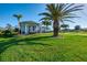 Home's yard with lush grass, mature landscaping, and a light blue home in the background at 1061 Boundary Blvd, Rotonda West, FL 33947