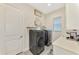 Functional laundry room with modern washer and dryer, ample shelving, and a utility sink at 1061 Boundary Blvd, Rotonda West, FL 33947