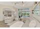 Bright living room features white furniture, an ornate ceiling fan, and pool views through large windows at 1061 Boundary Blvd, Rotonda West, FL 33947