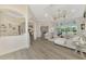 Spacious living room featuring white couches and chairs, large windows overlooking a pool, and an ornate ceiling fan at 1061 Boundary Blvd, Rotonda West, FL 33947