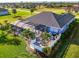 Backyard aerial showcases screened-in pool, and a patio in a landscaped yard with a modern fence at 1061 Boundary Blvd, Rotonda West, FL 33947