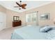 Relaxing bedroom with ceiling fan, dresser, and soft bedding at 10820 Trophy Dr, Englewood, FL 34223