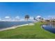 Scenic waterfront view with grassy area, palm trees and bench at 11000 Placida Rd # 201, Placida, FL 33946