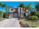 Two-story house with stone accents and palm trees at 117 Cable Dr, Rotonda West, FL 33947