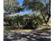 Tan one-story house with covered porch, palm trees, and lush landscaping at 1415 Winding Oak Dr, Port Charlotte, FL 33948